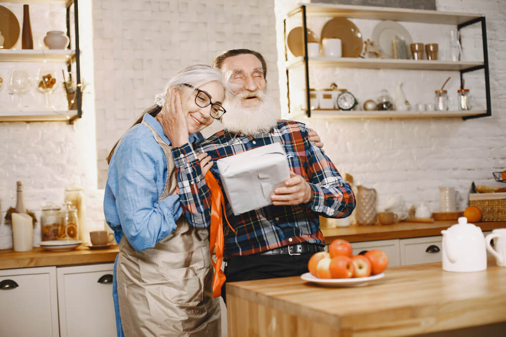 starsze osoby cieszą się ze wspólnego prezentu na dzień babci i dziadka